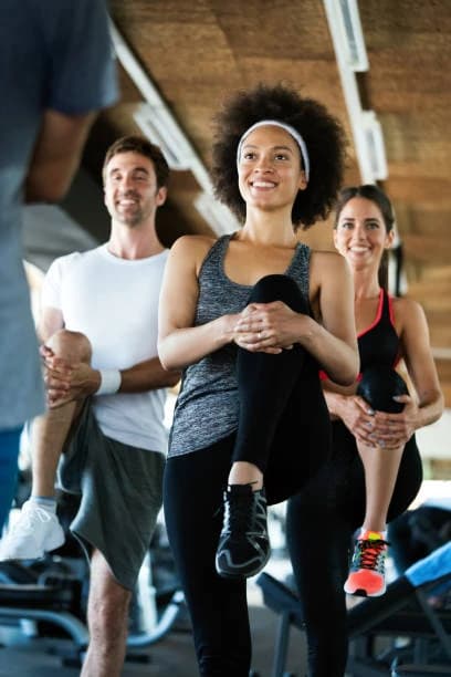 People smiling and stretching together at the gym